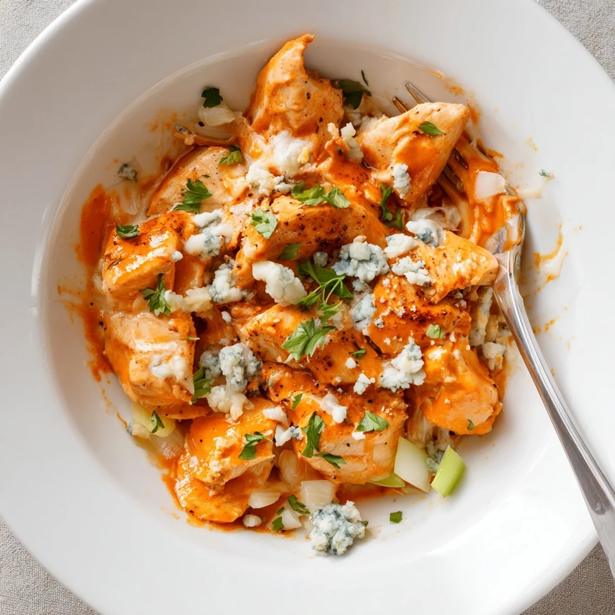 Keto Buffalo Chicken Skillet sizzling with melted mozzarella, creamy spicy sauce clinging
