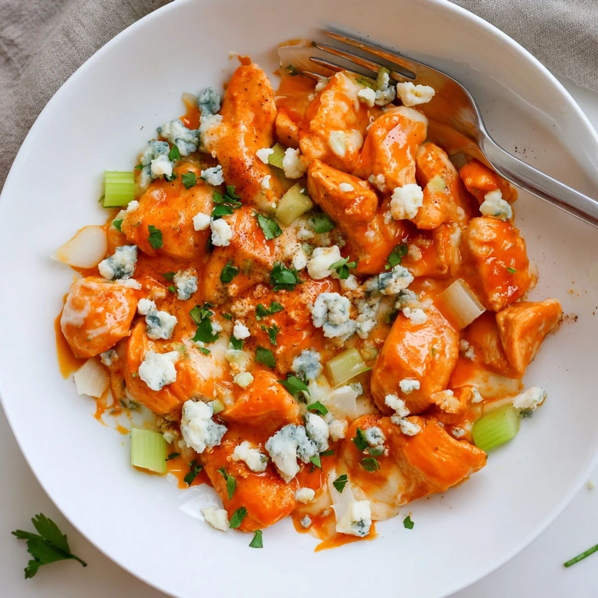 Keto Buffalo Chicken Skillet plated over cauliflower rice, tangy heat and blue cheese