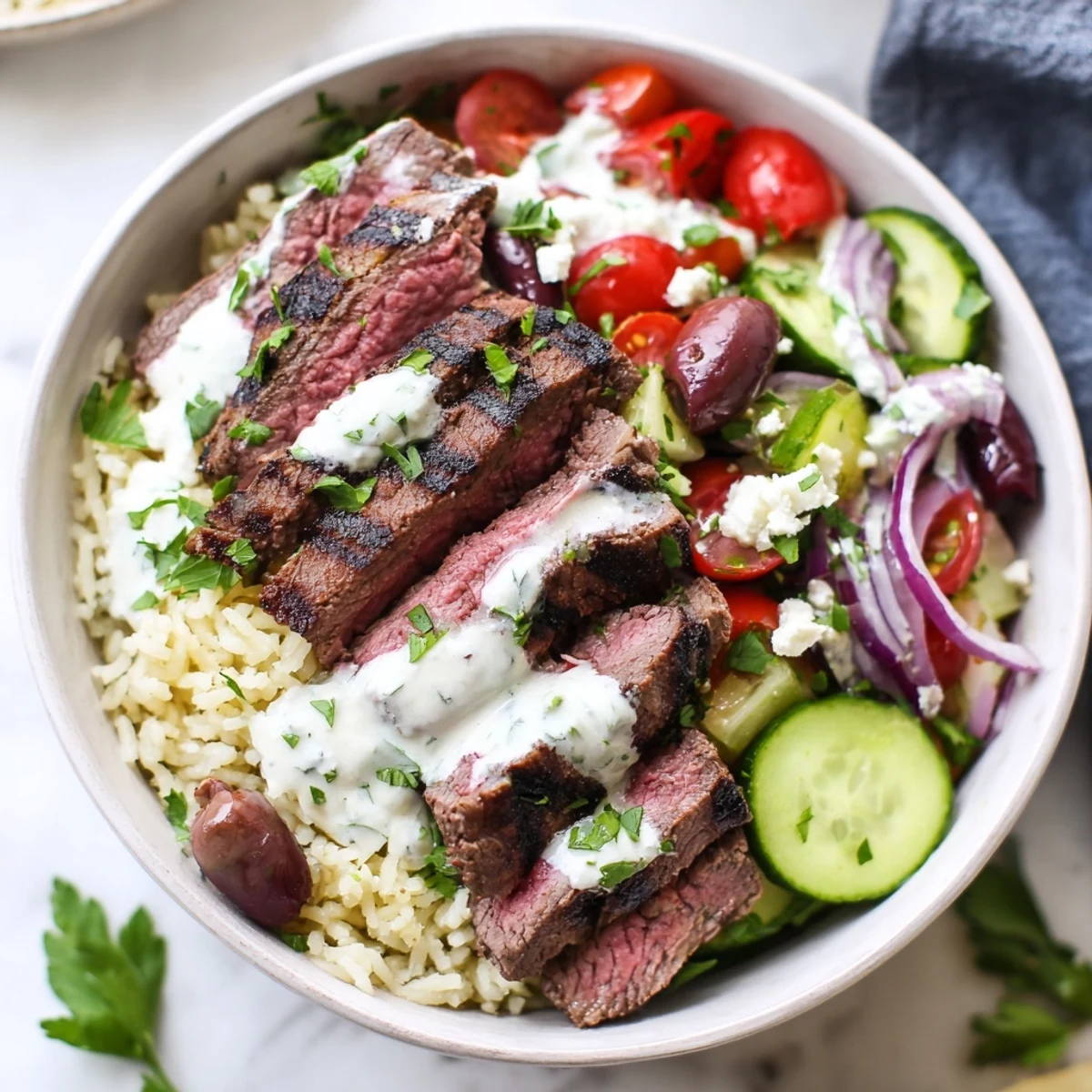 Juicy grilled Mediterranean steak bowl with fresh vegetables, herby rice, and zesty yogurt sauce