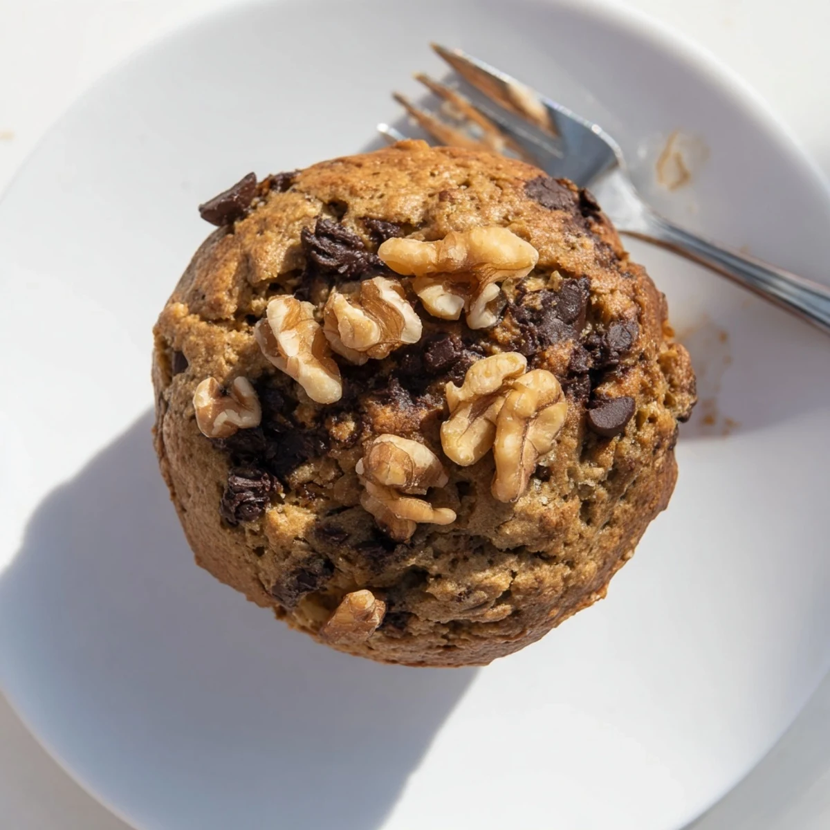 Moist wholesome healthy banana nut muffins drizzled with honey and sprinkled with cinnamon on a wooden board