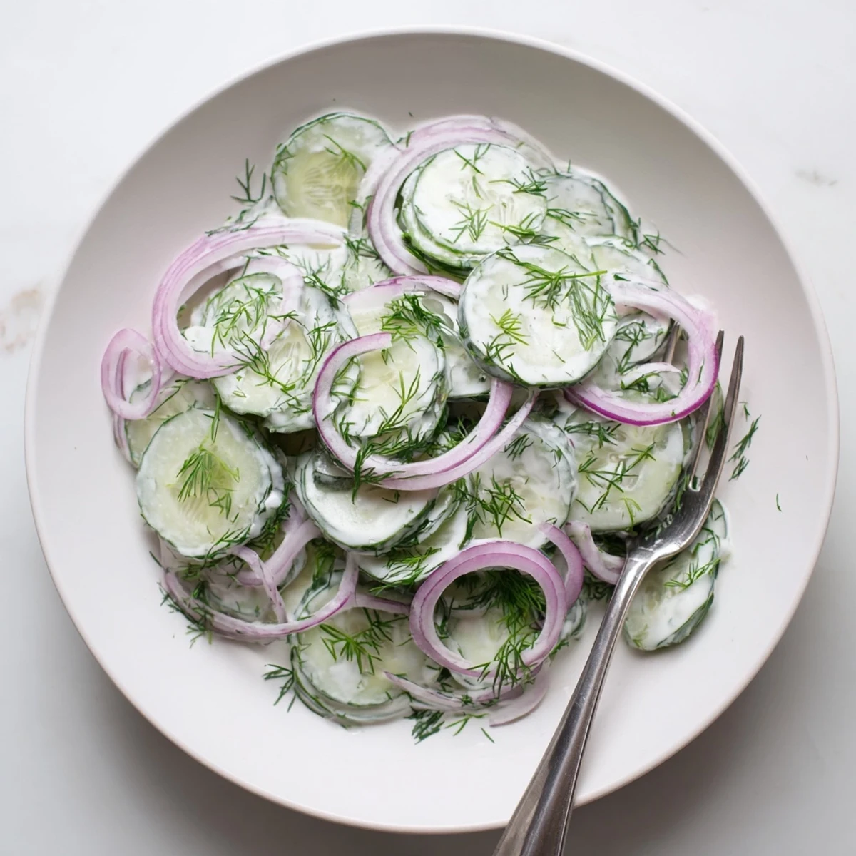 Fresh cucumber dill salad with thinly sliced cucumbers in creamy sour cream dressing