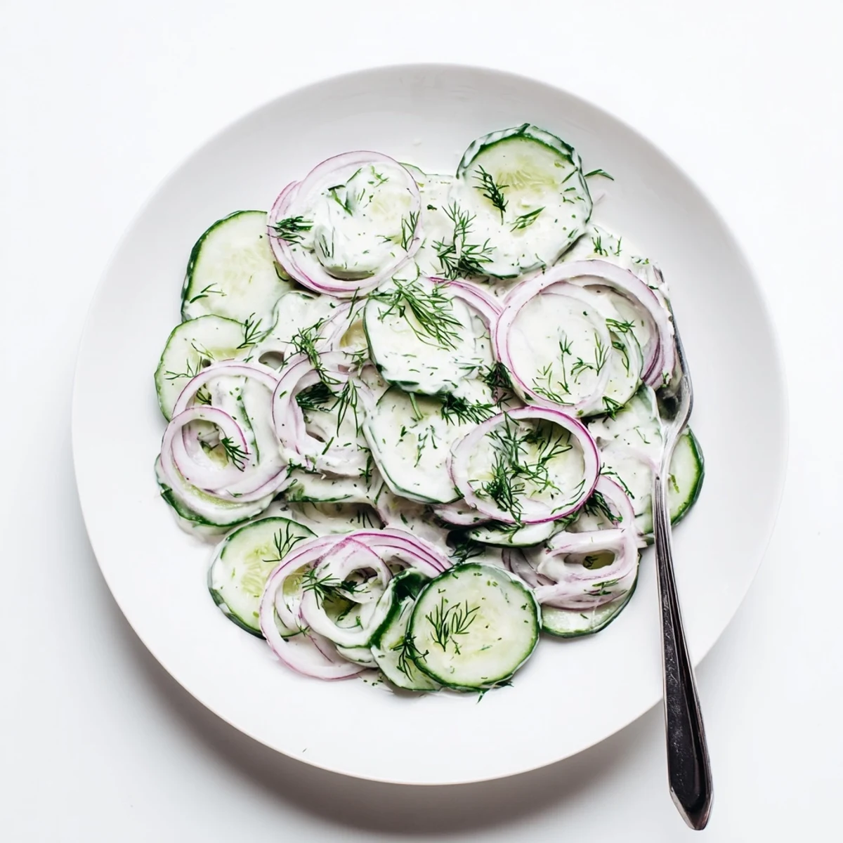 Creamy cucumber dill salad plated as refreshing summer side with chopped dill garnish