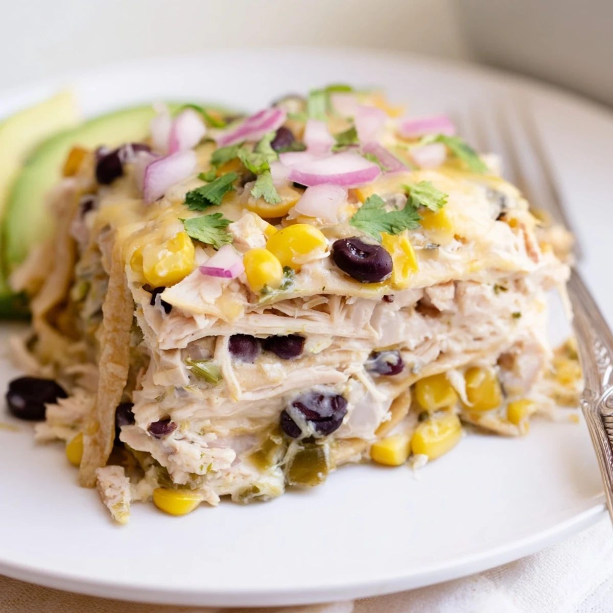 Oven baked Salsa Verde Chicken Casserole layered with tortillas, tender chicken, corn  