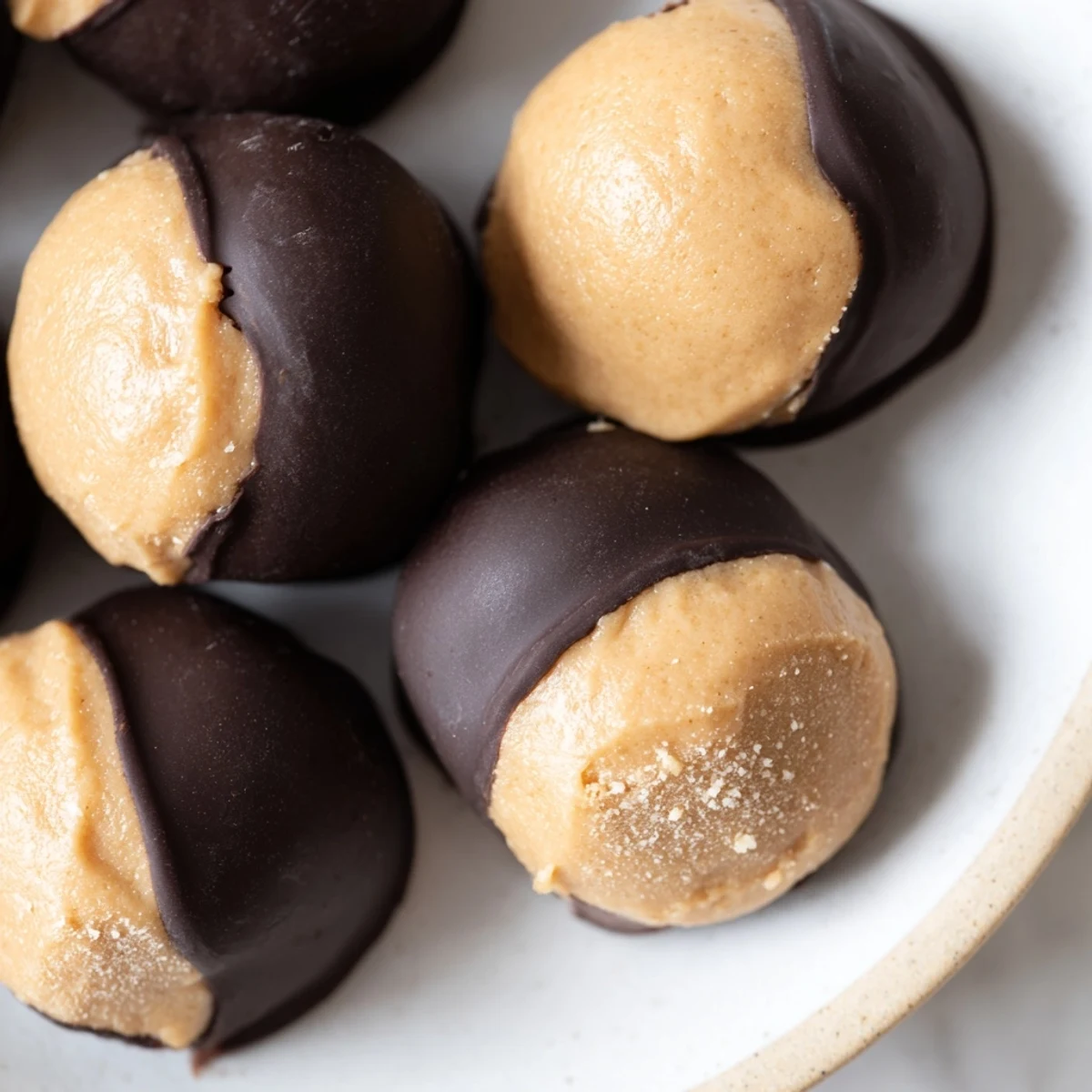 Golden peanut butter balls dipped in rich dark chocolate to make classic buckeye cookies