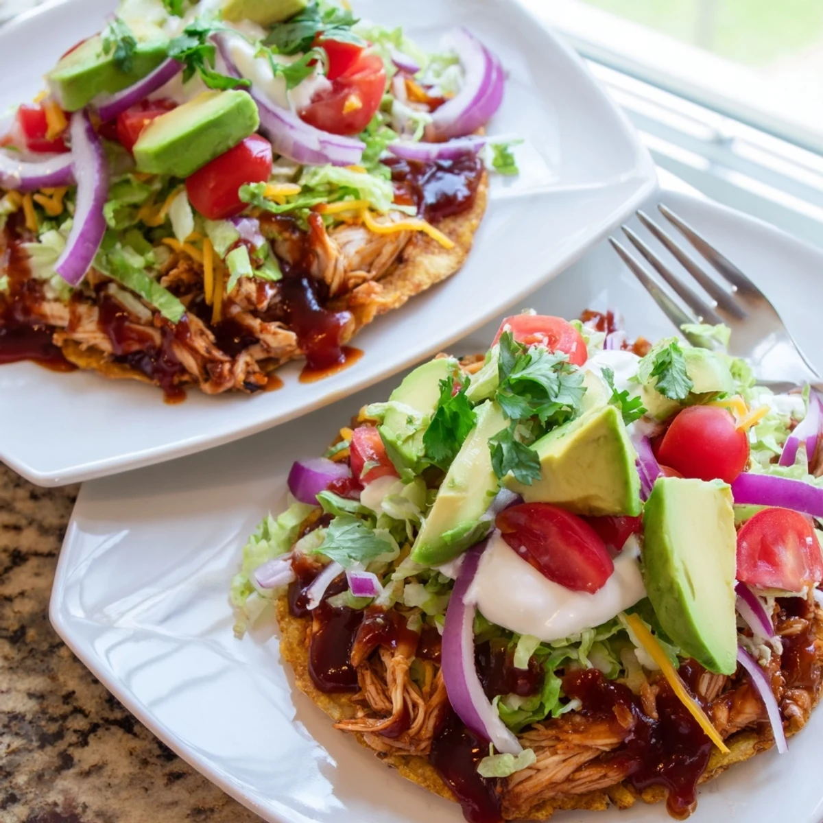 Crispy sweet smoky BBQ chicken tostadas loaded with fresh lettuce, tomato, and creamy avocado slices