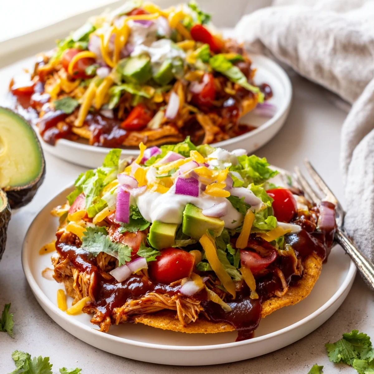 Golden corn tostada shells piled high with tender sweet smoky BBQ chicken and melted cheddar cheese