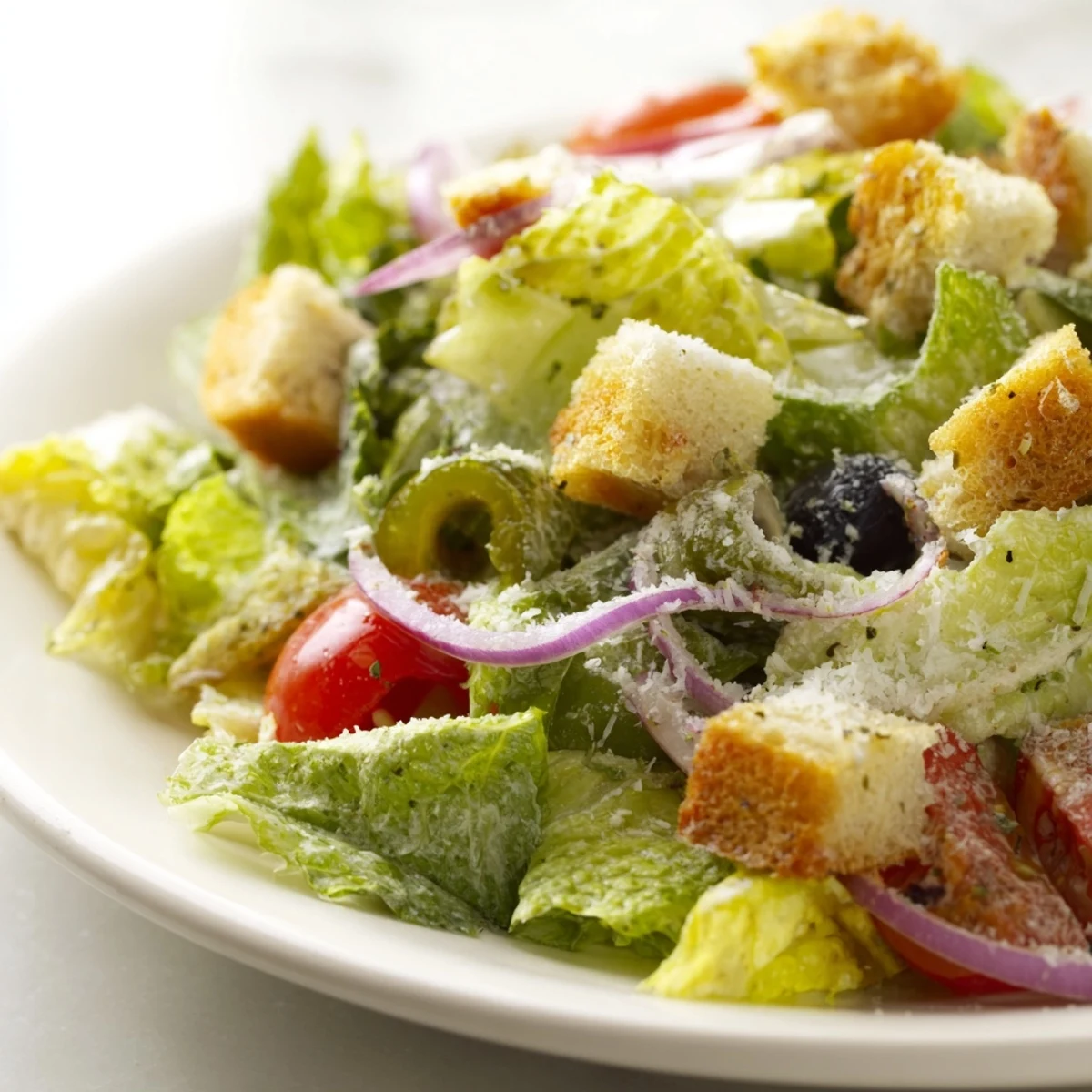 Colorful Olive Garden Salad served in a bowl with crunchy vegetables and shaved Parmesan