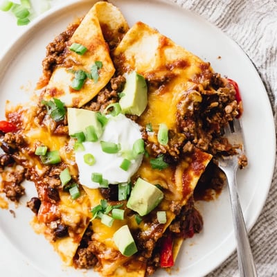 Hearty Beef Skillet Enchiladas served hot with creamy sour cream and avocado